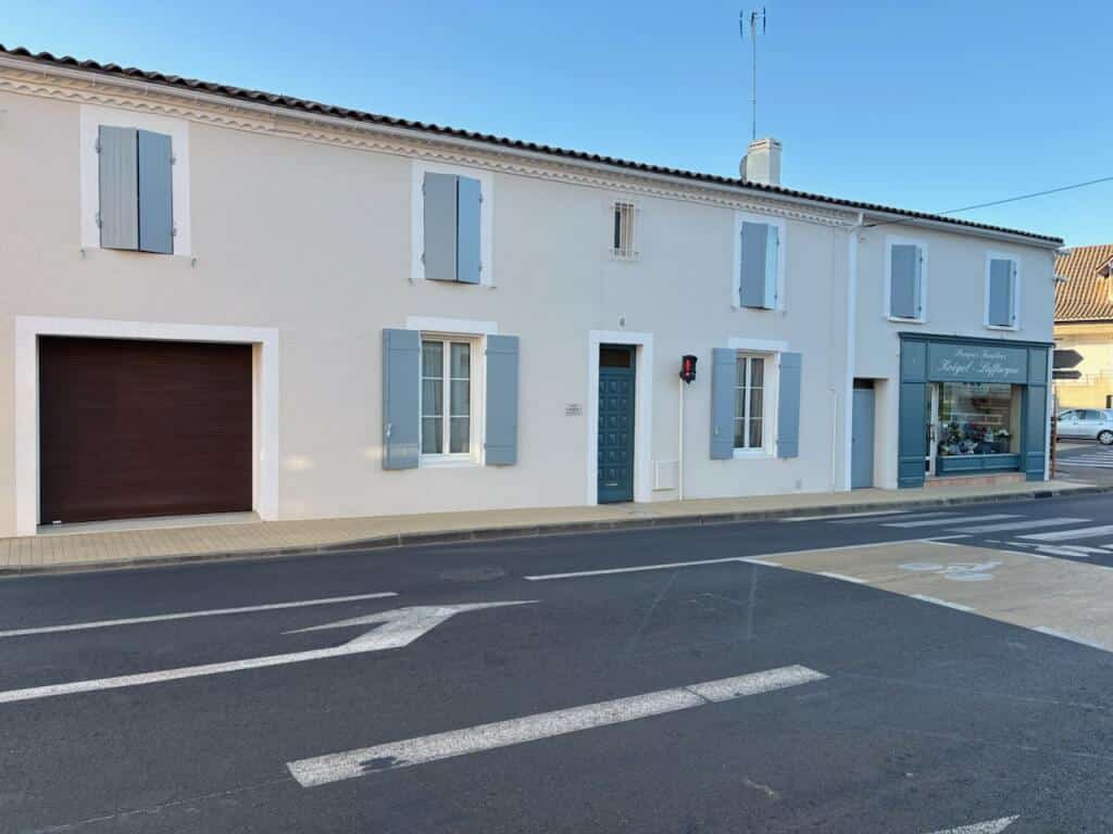 Façade avec volets bleus et enseigne Pompes Funèbres Koegel-Laffargue sur rue dégagée.